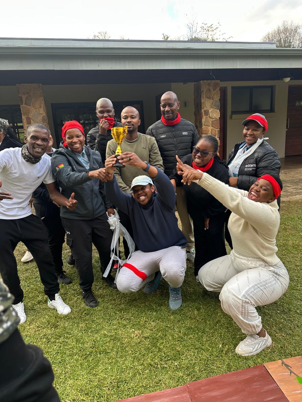 A winning team cheering with their gold trophy