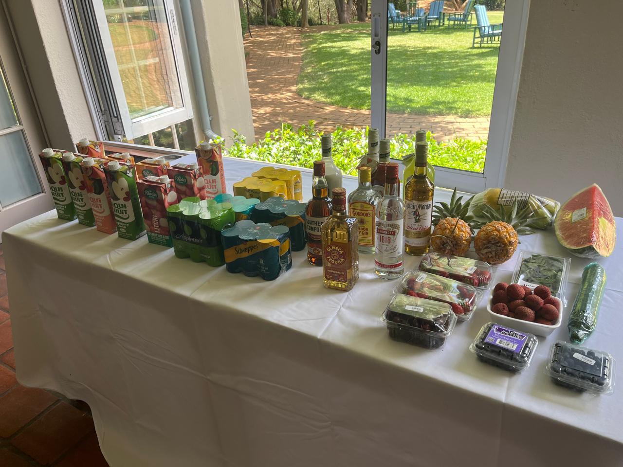 Cocktail station stocked with spirits, juices and fresh fruit