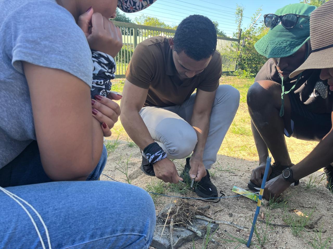 Team crouched together making fire in a survival challenge